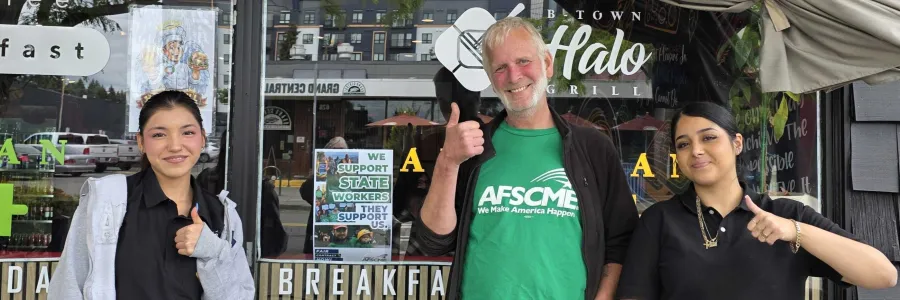 wfse member visiting store holding up sign with workers