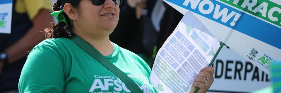 Image of Gabriella Pagdilao-Duras holding a sheet of chants at a rally at the Washington state capitol