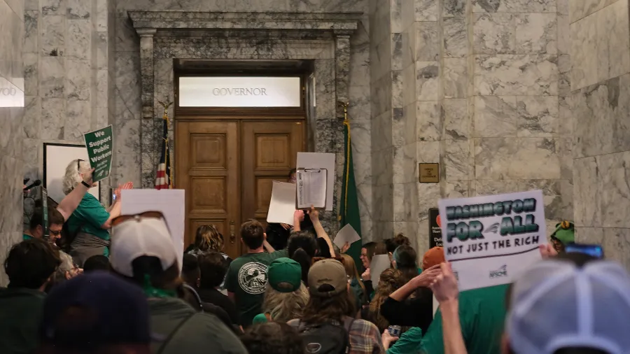 WFSE members holding signs and sitting outside of the governor's office