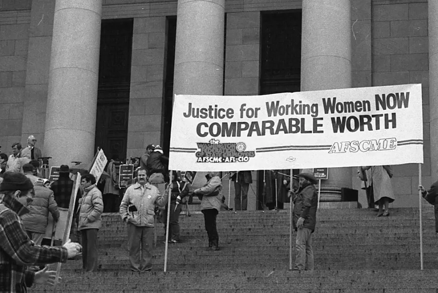 justice for working women now comparable worth, on a banner in front of the WA state capitol.