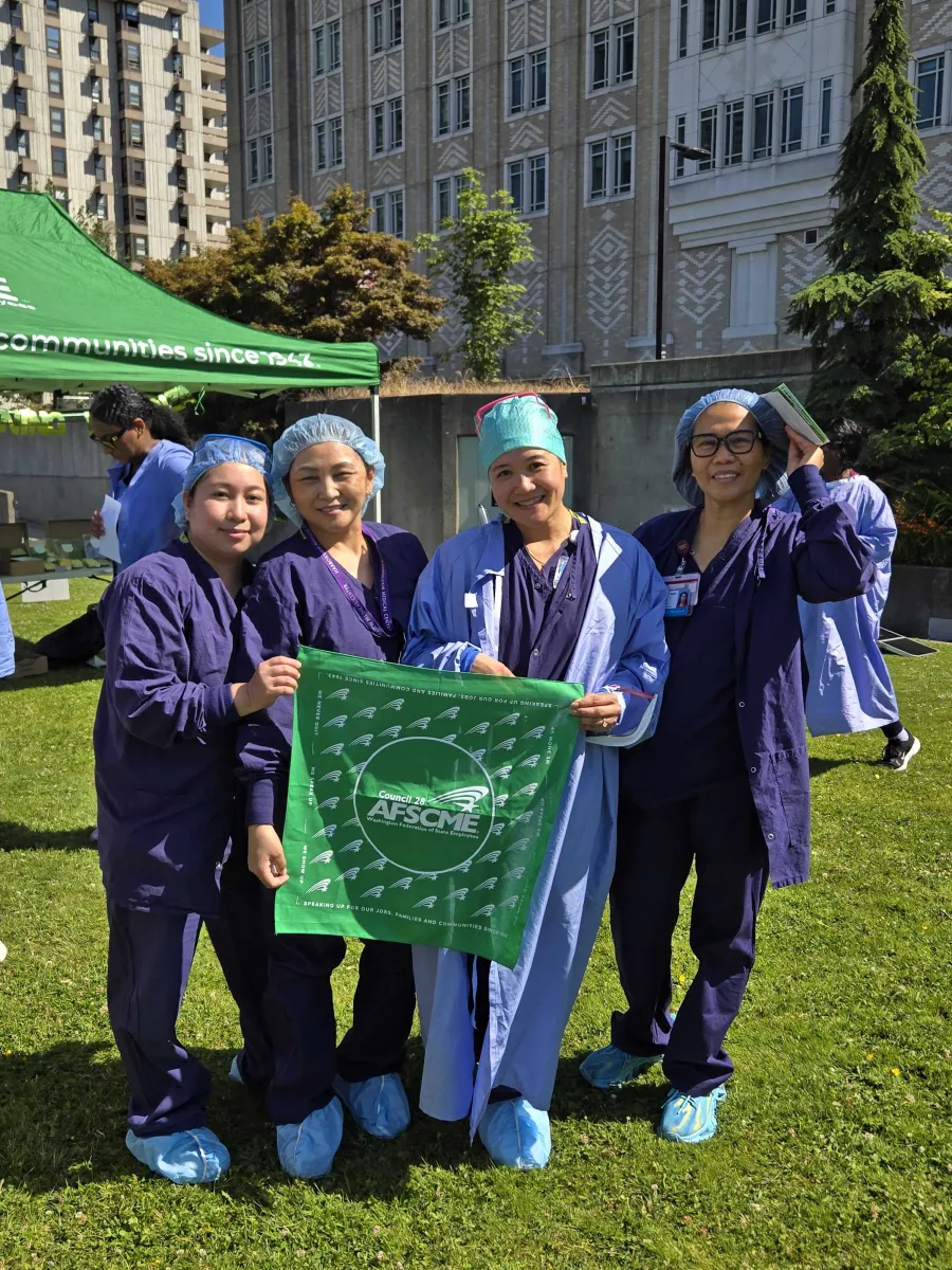 UW Members at Harborview hold up a WFSE bandana in their scrubs