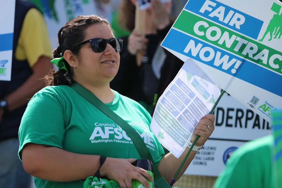 Image of Gabriella Pagdilao-Duras holding a sheet of chants at a rally at the Washington state capitol