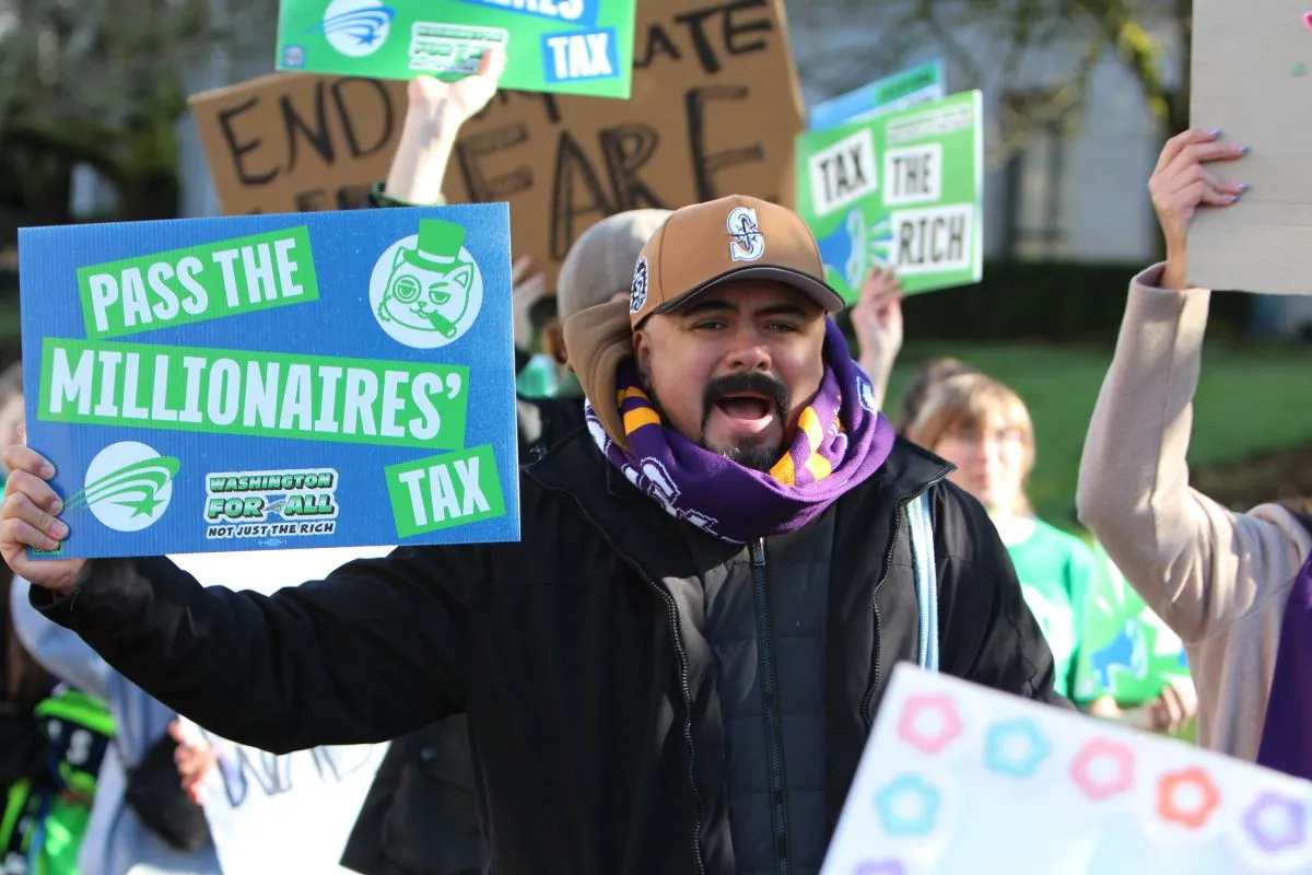 union member holding pass the millionaires tax sign