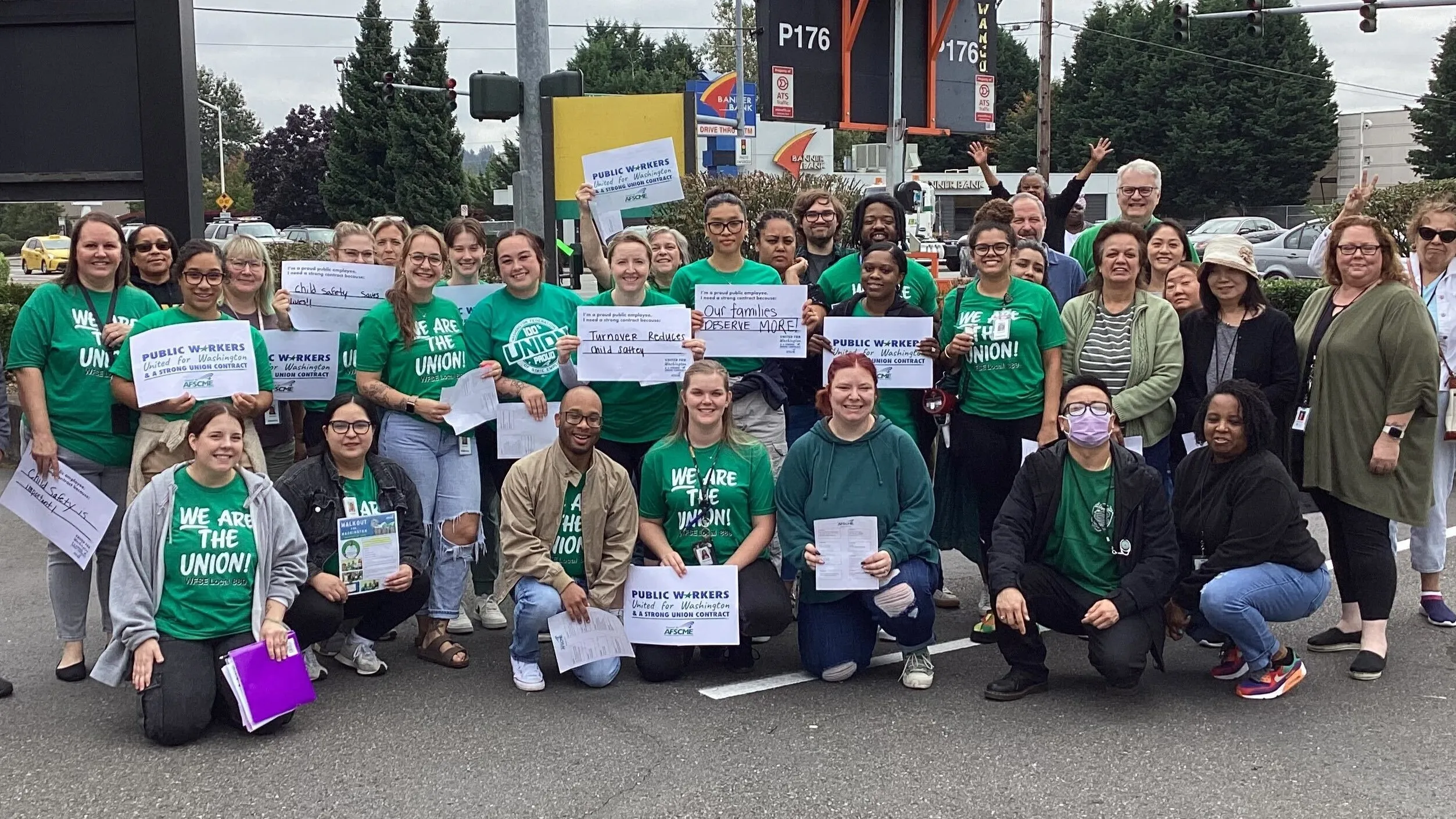 WFSE members during the walkout for Washington. A large group in green holding white signs.