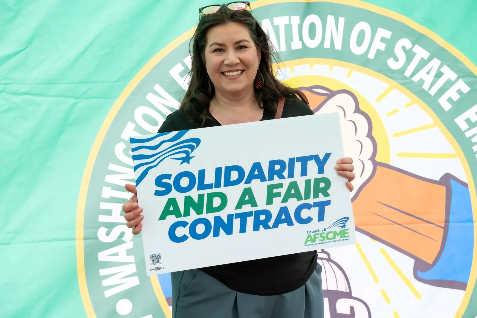 PSRW Olympia member holding fair contract sign