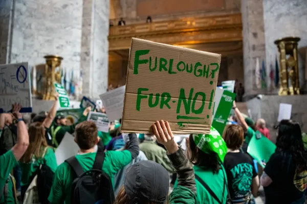 wfse member holding a sign at the capitol protesting proposed furloughs