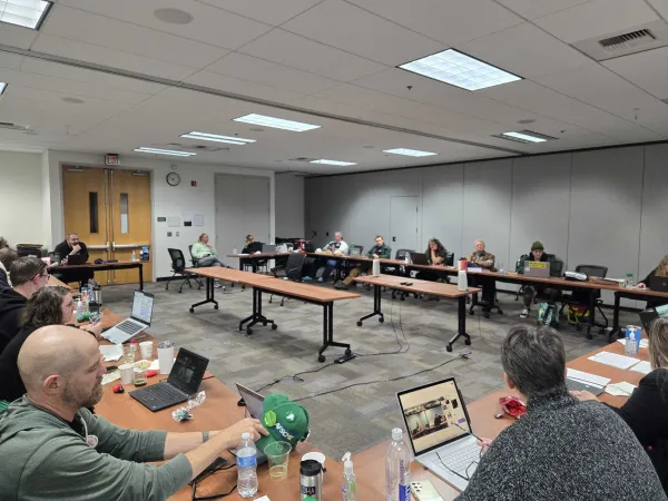 A photo of WFSE members and OFM representatives sitting around the bargaining table late at night