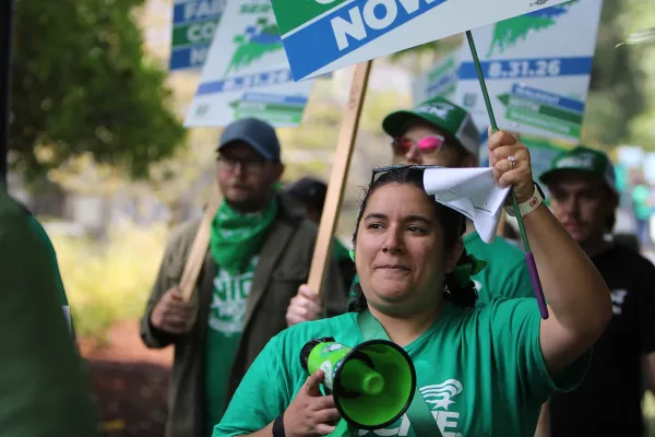 Image of Gabriella Pagdilao-Duras holding a bullhorn and leading chants at a rally at the Washington state capitol