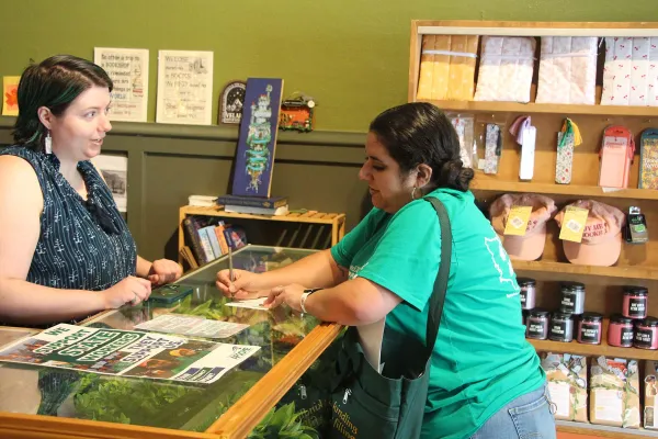 Image of Gabriella Pagdilao-Duras speaking to a local business owner during a community outreach event during the recent contract campaign