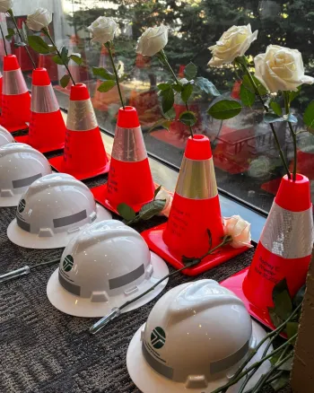 Photo of WSDOT memorial shows a row of orange cones and a row of white helmets