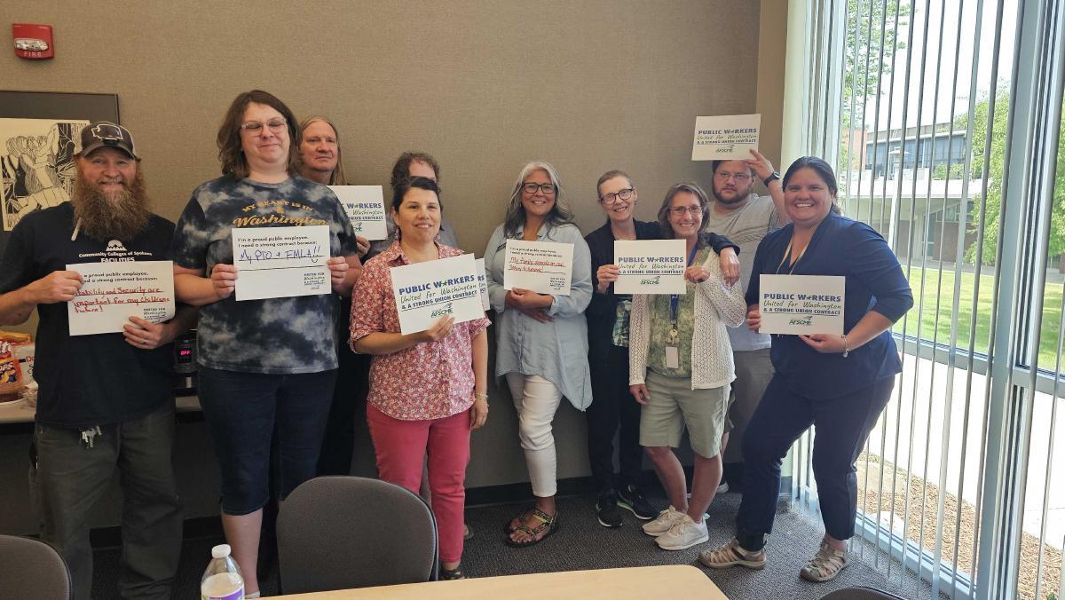 WFSE members at Spokane Falls Community College holding fair contract now signs